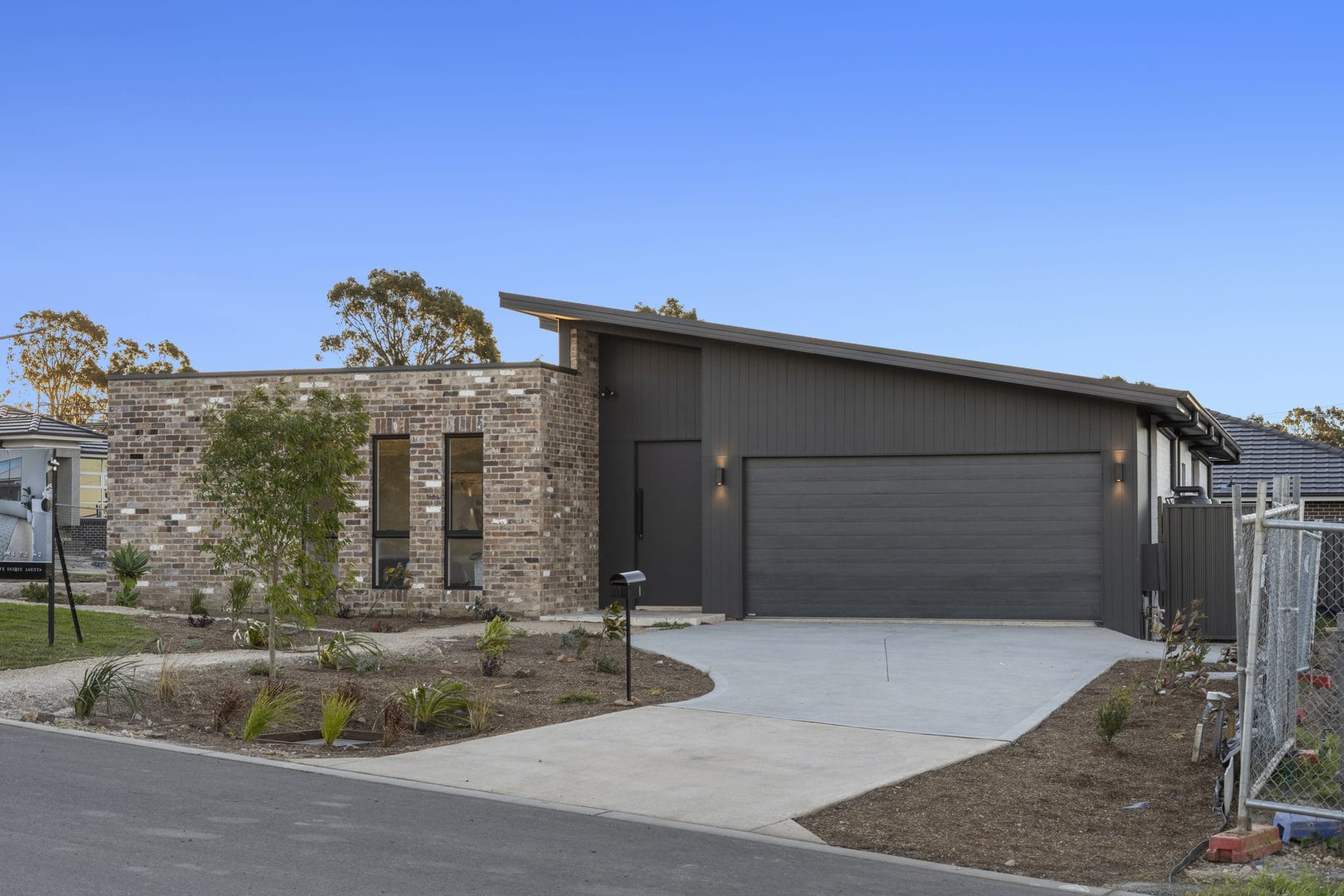 Single-storey custom home in recycled brick and dark cladding by Hills Homes